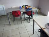 a table and chairs in a room with white tile flooring