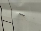 a white car with a hole in the side of it ' s door