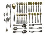 a lot of silver spoons and forks on a white surface