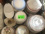 une valise remplie d'assiettes et de bols posée par terre