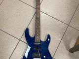 une guitare électrique bleue posée par terre dans une pièce
