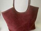 burgundy sued tote bag with leather handles and zipper closure