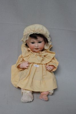 a small doll with a bonnet on it ' s head