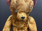 a brown teddy bear with a red patch on it ' s chest