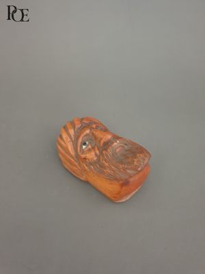 an image of a small carved object sitting on top of a table