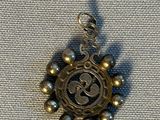 une photo d'un pendentif sur lequel figure une horloge