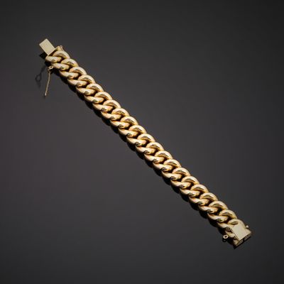 a gold bracelet with a chain on a black background