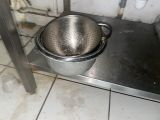 une casserole posée sur une étagère en métal dans une cuisine