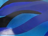 a close up of a blue and black vase on a table