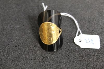une bague noire et dorée ornée d'un motif doré