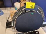 un haut-parleur bleu et noir posé sur un bureau, sur lequel est collé un autocollant jaune