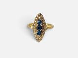 une photo d'une bague en or sertie d'un saphir bleu et de diamants
