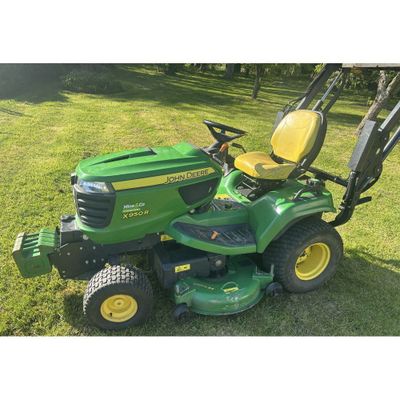 a green lawn mower sitting on top of a lush green field