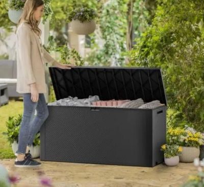 une femme debout à côté d'un coffre de rangement extérieur noir