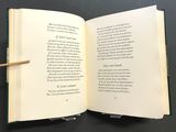 an open book with a pencil sticking out of it sitting on a table