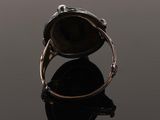 a close up of a ring on a black surface with a reflection
