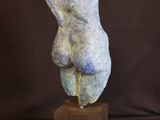 sculpture of a hand on a wooden block with a black background