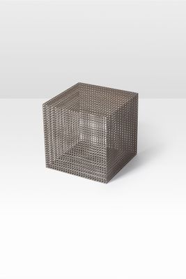 a gray wicker cube on a white surface with a white background