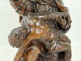 statue of a woman holding a child on her lap with a dog
