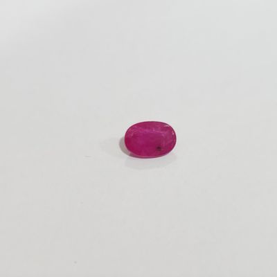 une pierre ovale rose sur une surface blanche
