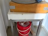 a red bucket sitting on a metal table next to a red bucket