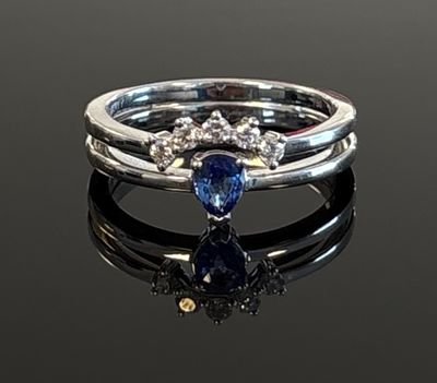 a close up of a ring on a black surface with a blue stone