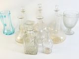de nombreux vases en verre de différentes formes posés sur une surface blanche