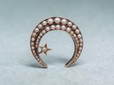 a close up of a gold crescent with pearls and a star