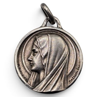 une médaille d'argent sur laquelle est représenté le visage d'une femme
