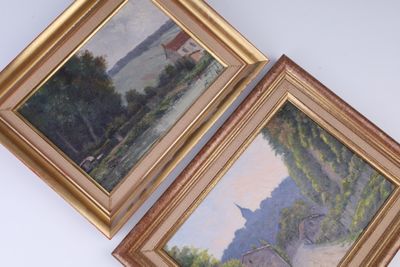 Deux tableaux représentant des arbres et un bâtiment sont accrochés au mur.