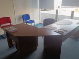 a desk and chairs in a room with a large window
