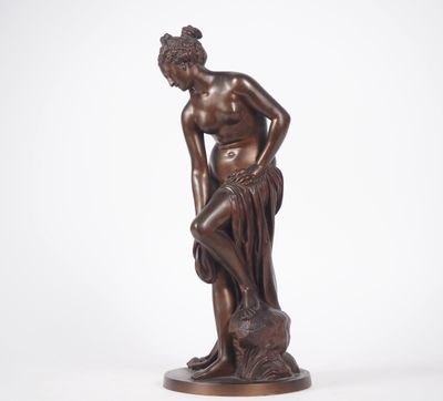 une statue en bronze représentant un homme assis sur un rocher