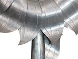 a metal sculpture of a sunflower with a mirror in the middle
