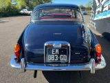 une voiture bleue garée sur un parking, avec d'autres voitures en arrière-plan