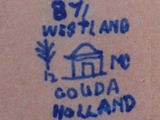 a close up of a blue and white tile with a house on it