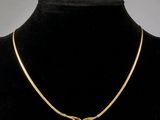 un gros plan d'un collier en or autour du cou d'un mannequin