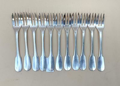 six fourchettes alignées sur une table