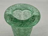 a green glass vase with a heart inside of it