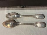 two silver spoons and a fork sitting on a table