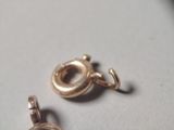 two charms that are sitting on a white surface