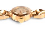 a gold watch with a chain around it on a white surface