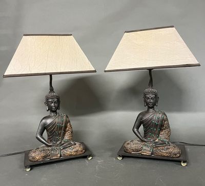 une paire de lampes en bronze représentant des bouddhas, munies d'abat-jour