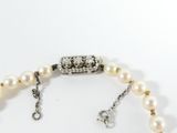 an image of a white pearl necklace with a silver clasp