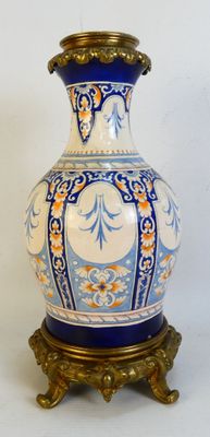a blue and white vase sitting on a gold stand