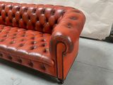 a red leather couch that is sitting in a room