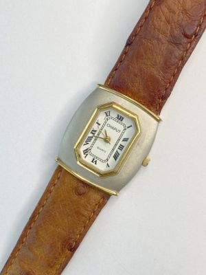 une montre posée sur une surface blanche