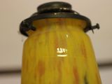 a yellow vase with a black top on a table