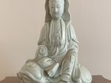 une petite statue représentant une personne assise sur une table