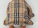 baby in a burbersuit with a plaid blanket on it ' s back