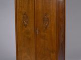 une armoire ancienne en bois, dotée de deux portes et d'une étagère au-dessus